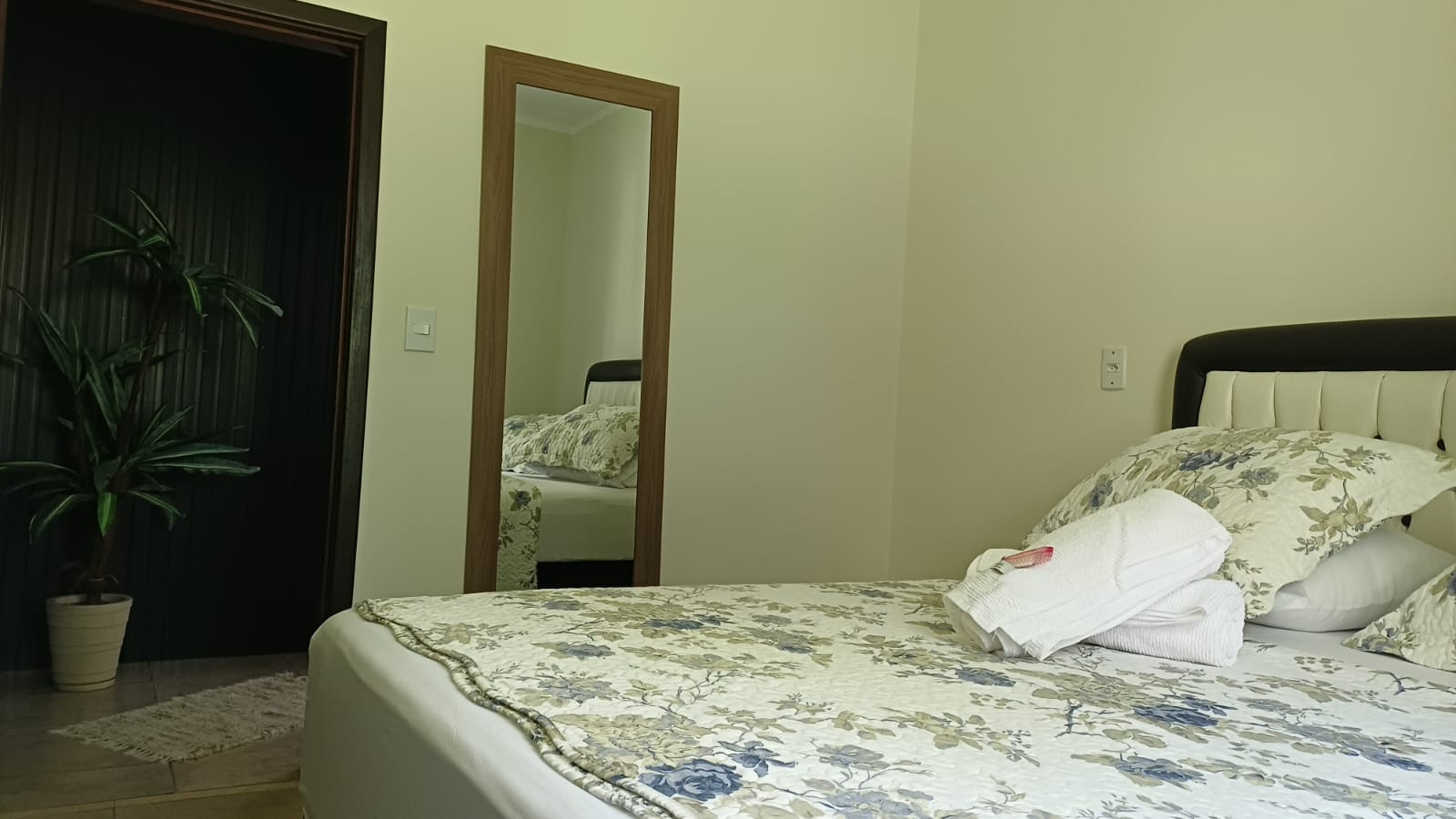 Quarto com espelho de corpo inteiro e cama de casal